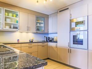 モントルーにあるApartment Le National Montreux-21 by Interhomeのキッチン(白いキャビネット、花崗岩のカウンタートップ付)