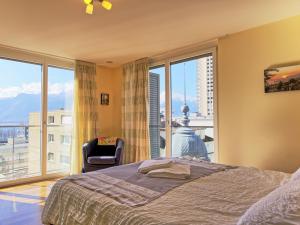 een slaapkamer met een bed en een groot raam bij Apartment Le National Montreux-21 by Interhome in Montreux