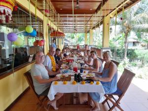 a group of people sitting at a table in a restaurant at Camplung Beach Family Villa and Farmstead in Tejakula