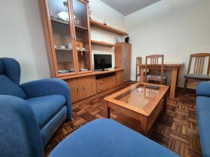 Sala de estar con 2 sofás azules y mesa de centro en Apartamento Bedriñana 209A, en Villaviciosa