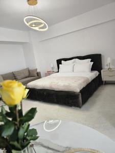 a bedroom with a black bed and a couch at Studio 126 in Eforie Nord