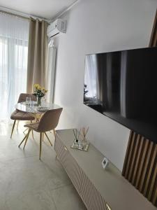 a living room with a table and a large television at Studio 126 in Eforie Nord