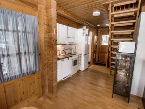 a kitchen with white appliances and wooden walls at Holiday Home Selja 5 by Interhome in Isnäs +9 photos