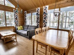a living room with a wooden table and a couch at Holiday Home Selja 5 by Interhome in Isnäs