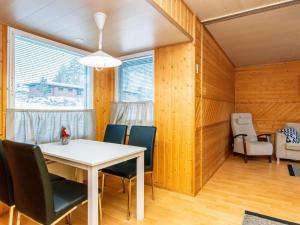 une salle à manger avec une table et des chaises blanches dans l'établissement Holiday Home Huhmari 16 by Interhome, à Polvijärvi