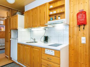 une cuisine avec des armoires en bois et un réfrigérateur blanc dans l'établissement Holiday Home Huhmari 16 by Interhome, à Polvijärvi