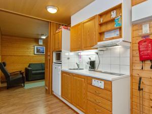 une petite cuisine avec un évier et une cuisinière dans l'établissement Holiday Home Huhmari 15 by Interhome, à Polvijärvi