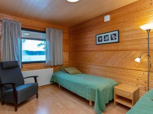 une chambre avec un lit et une chaise dans une pièce dans l'établissement Holiday Home Huhmari 15 by Interhome, à Polvijärvi 13 autres photos