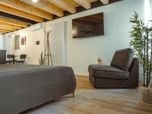 a living room with a bed and a chair at BRE Apartments - Pax in Vicenza