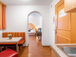 a kitchen with a table and a room with a bed at Apartment Rosa-9 by Interhome in Mayrhofen +19 photos
