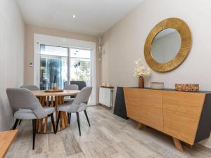 a dining room with a table and chairs and a mirror at Villa Evian by Interhome in Miami Platja