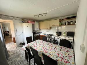 a kitchen with a table with a flowered table cloth at Le Clos Ampère - maison avec jardin & Clim in Toulouse