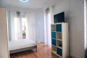 a bedroom with a bed and a tv on a shelf at Casa San Roque in Seville