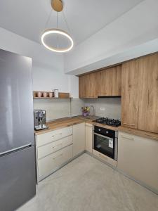 a kitchen with wooden cabinets and a stove top oven at Studio 126 in Eforie Nord