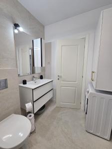 a white bathroom with a sink and a toilet at Studio 126 in Eforie Nord +7 photos