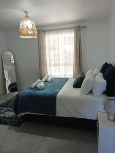 ケープタウンにあるPinelands One-bedroom Apartmentの大きなベッドと窓のある寝室