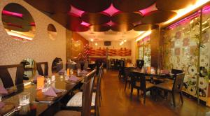 a dining room with tables and chairs in a restaurant at The New Marrion in Bhubaneshwar