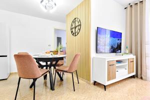 a living room with a dining table and a tv at Home&Holiday Andalisa in Torrevieja