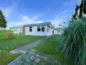 a white house with a grass yard at 2 bed chalet beaches nearby in Roch