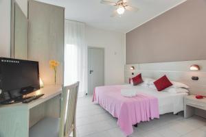 sypialnia z łóżkiem z różowym kocem w obiekcie Hotel Joli w Cesenatico