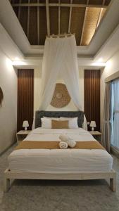 a bedroom with a large bed with a canopy at Hamra Villa in Jimbaran +63 photos