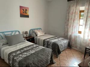 a bedroom with two beds and a window at Casa Juana Arisgotas in Arisgotas