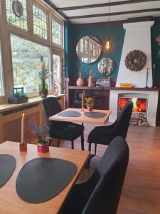 a living room with tables and chairs and a fireplace at Herberg de la Ruïne in Valkenburg +23 photos