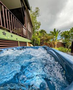 a blue pool of water in front of a house at Villa Créole avec Jacuzzi à la Rivière in La Rivière