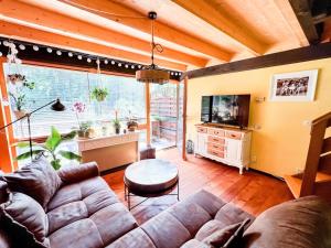 a living room with a couch and a tv at Geographer`s Cottage II in Siegsdorf