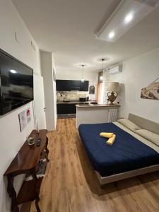 a bedroom with a blue bed and a kitchen at Palmina's Apartments in Brindisi