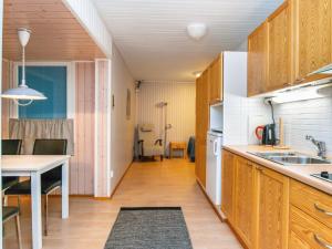 une cuisine avec des placards en bois et une salle à manger dans l'établissement Holiday Home Huhmari 21 by Interhome, à Polvijärvi