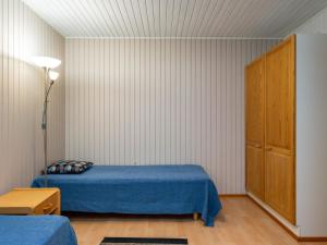 - une chambre avec un lit bleu et une armoire dans l'établissement Holiday Home Huhmari 21 by Interhome, à Polvijärvi
