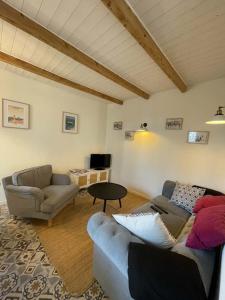 a living room with two couches and a table at Maison de pêcheur in Perros-Guirec