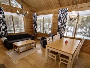 a living room with a table and a couch at Holiday Home Puolukka 2 by Interhome in Isnäs