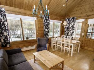 a living room with a couch and a table and chairs at Holiday Home Puolukka 2 by Interhome in Isnäs