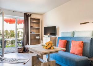 Una sala de estar con un sofá azul y una mesa. en WS Ferienwohnung Meer, en Gelting