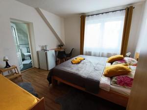 a bedroom with a bed with yellow pillows and a window at Ubytování Pohoda in Třeboň