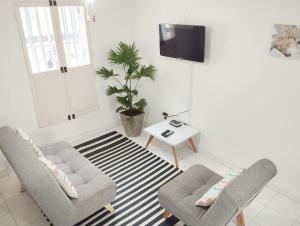 a living room with two chairs and a tv at Apto Centro Ciudad Amurallada - Centro Historico - Q in Cartagena de Indias