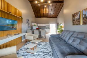 a living room with a couch and a dining room at Pousada Natribus Rosa in Praia do Rosa