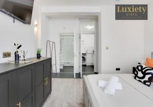 a bedroom with a bed and a sink and a bathroom at Chic & Stylish Studio City Centre Nr High St by Luxiety Stays in Southend-on-Sea