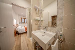 łazienka z białą umywalką i sypialnia w obiekcie Perugia Apartments w mieście Perugia +37 zdjęć