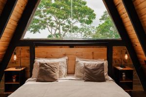 a bed in a room with a large window at Cabana Jequitibá in Maria da Fé