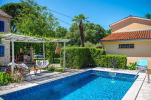 a swimming pool in front of a house at Casa Oliva by Kompas Villas in Čepljani