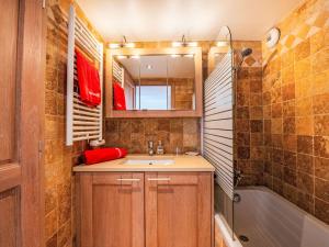 a bathroom with a sink and a mirror and a tub at Apartment Le Domaine de la Baie-4 by Interhome in Cavalaire-sur-Mer