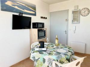 una sala da pranzo con un tavolo e una tv di Apartment Le Beaufort by Interhome ad Arcachon Altre 17 foto