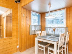 une salle à manger avec une table et des chaises blanches dans l'établissement Holiday Home Huhmari 17 by Interhome, à Polvijärvi