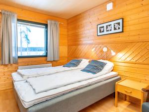 une chambre avec un lit dans une pièce en bois dans l'établissement Holiday Home Huhmari 17 by Interhome, à Polvijärvi