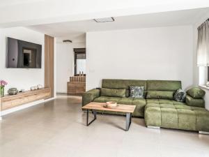 a living room with a green couch and a coffee table at Holiday Home Holiday House Arni by Interhome in Delnice