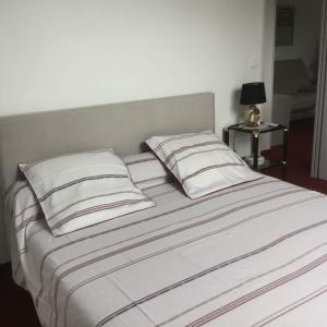 Una cama blanca con dos almohadas encima. en maison d hôtes, en Saint-Planchers