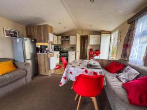 ein Wohnzimmer mit Tisch und Couch in der Unterkunft Dog Friendly 8 Berth Caravan At Dovercourt Holiday Park In Essex Ref 44504P in Great Oakley